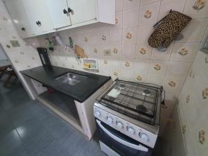 2 quadras praia da enseada guarujá região aquario في غوارويا: مطبخ صغير مع موقد ومغسلة