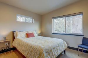 a bedroom with a bed and a window and a blue chair at Urban Roundabout in Bend