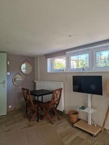 Una sala de estar con una mesa y sillas y un televisor. en Jeanmyr, en Sainte-Marie-aux-Mines 7 fotos más