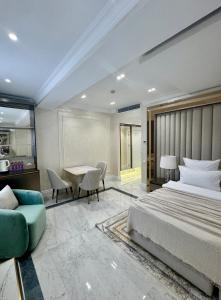 um quarto com uma cama, uma mesa e um sofá em Ganjali Plaza Hotel em Baku