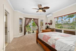 a bedroom with a bed and a ceiling fan at Princeville/Hanalei Lux 4BR 3.5Ba w/AC+CAR in Princeville