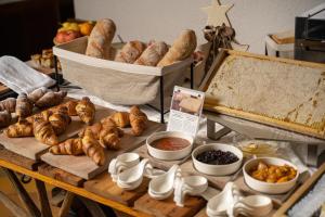 uma mesa com vários tipos de pão e croissants em Rifugio Cereda - Dormitory em San Martino di Castrozza