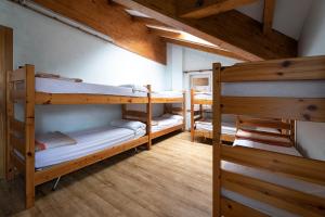 3 beliches num quarto com tectos em madeira em Rifugio Cereda - Dormitory em San Martino di Castrozza