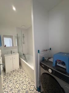 a bathroom with a tub and a shower and a sink at Digue & Dream - 4-person apartment in Dunkerque