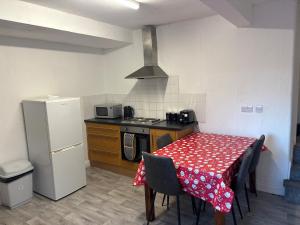 een keuken met een tafel, een fornuis en een koelkast bij Zinoc Seaside Apartment in Murton