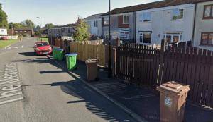 una strada con una recinzione e bidoni della spazzatura di Middleton 4 Bed Free Parking Long stays a Middleton