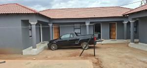 a black car parked in front of a house at Magoveni Accommodation in Mariveni