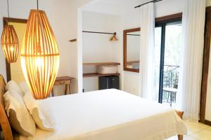 um quarto com uma cama branca e uma janela em Villa Santa Fé em Búzios