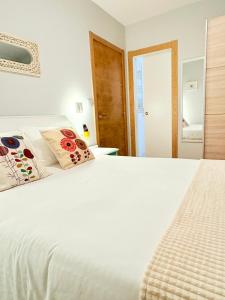 a bedroom with a white bed with two pillows at Casa CAMPELO- Playas de Pinténs - CANGAS-HIO- Ría de Aldán in Cangas de Morrazo +56 photos