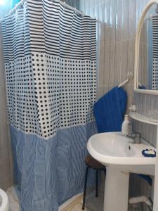 um banheiro com pia e cortina de chuveiro em Location saisonnière entre mer, forêt et calme em Raʼs al Jabal mais 42 fotografias