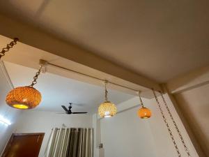 tres luces colgando del techo de una habitación en A2 Homestay, en Guwahati