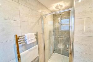 a shower with a glass door in a bathroom at Central and Stylish, Garden and Parking in Coventry +17 photos