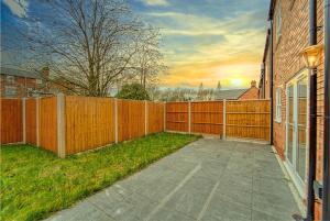 a backyard with a wooden fence and a sidewalk at Central and Stylish, Garden and Parking in Coventry