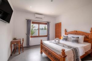 克拉玛斯Tridatu Villas Keramas的一间卧室，配有一张床、一张书桌和一扇窗户