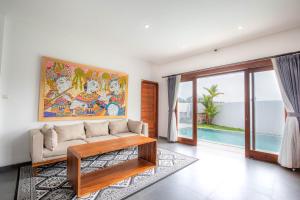 克拉玛斯Tridatu Villas Keramas的客厅里有一张沙发，墙上挂着一幅画