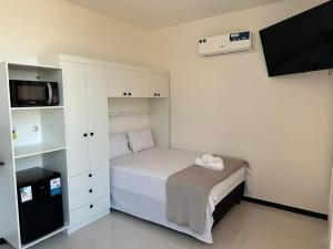 a small bedroom with a bed and a tv at Cabanos Prime Hotel e Residencial in Barcarena