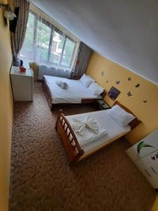 a hotel room with two beds and a window at Casa Adelina in Băile Herculane