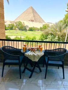a table and chairs with a view of the pyramids at Glamour Pyramids BoutiQue Hotel in Cairo