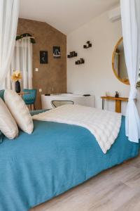 Un dormitorio con una cama grande con una manta azul. en Rendez-vous Secret, en Lunas