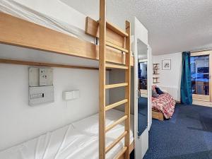 葱仁谷appartement ski au pied residence altineige val thorens的一间带双层床的卧室和一间带梯子的双层床间