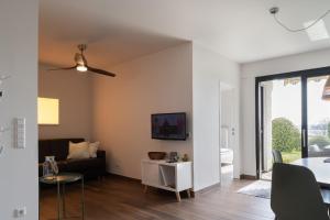 a living room with a couch and a ceiling fan at Seepanorama in Unteruhldingen