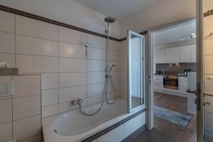 a bathroom with a bath tub and a kitchen at Seepanorama in Unteruhldingen +18 photos