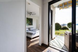 a bedroom with a bed and a sliding glass door at Seepanorama in Unteruhldingen