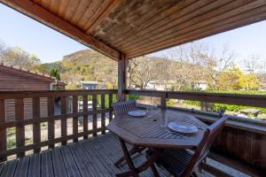 Roquefeuilchalet montana 5_4 pers的一个有桌子和椅子的木甲板