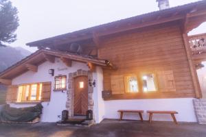 a wooden house with two benches in front of it at Chalet 8p Villars-sur-Ollon, Parking et Jardin in Ollon