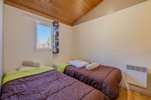 Roquefeuilchalet montana 5_4 pers的有窗户的房间里有两张床