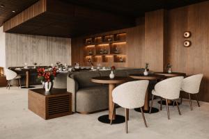 a restaurant with tables and a couch and chairs at Hotel Oberforsthof in Sankt Johann im Pongau