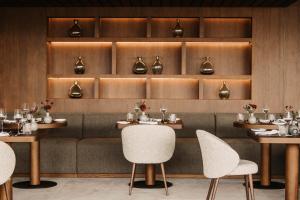 a dining room with tables and chairs and shelves at Hotel Oberforsthof in Sankt Johann im Pongau