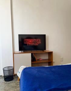 a flat screen tv sitting on a stand in a room at Quarto Privativo na AvBeira mar - Apto familiar in Fortaleza +30 photos
