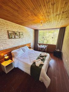 Un dormitorio con una cama grande con techo de madera. en Pousada All Green - Monte Verde, en Monte Verde