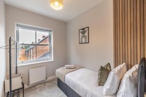 a bedroom with a bed and a window at 4 Bed House in Coventry City Centre, by ARP HOMES, Driveway & Garage, Big Garden, Ideal for Contractors, Families and Long Stays in Coventry