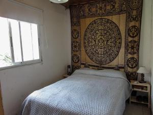 a bedroom with a bed with a large tapestry on the wall at La Maruja de Acantilados in Mar del Plata
