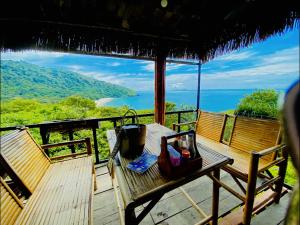 a table on a deck with a view of the ocean at Baan Amila in Phra Ae beach
