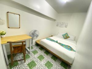 Un dormitorio pequeño con una cama y un escritorio. en Baan Amila, en Phra Ae beach
