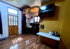 a living room with a kitchen with a tv on the wall at Forest Valley Homestay in La Trinidad