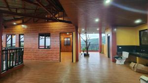 a large room with a wooden floor and a hallway at Forest Valley Homestay in La Trinidad