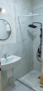 a white bathroom with a sink and a mirror at CALLA 5 Apartment - Main Square, in the City Shopping Center - PARKING SLOT WITH SECURITY AND VIDEO CAMERA in Skopje