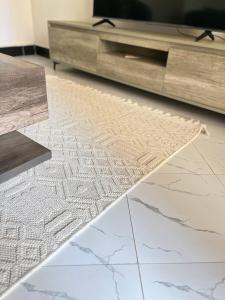 ein Wohnzimmer mit einem TV und einem Teppich auf dem Boden in der Unterkunft P&P homes in Kampala