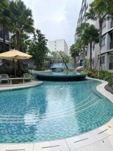 a swimming pool in a city with palm trees at DCondo Kathu ใกล้หาดป่าตอง in Kathu