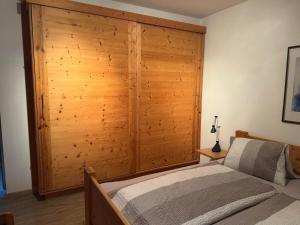 sypialnia z drewnianą ścianą obok łóżka w obiekcie Ferienwohnung Eichenspaziert w mieście Hart im Zillertal