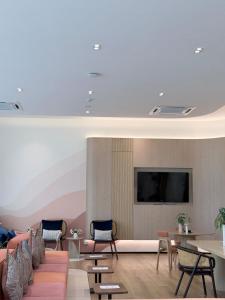 a living room with a couch and chairs and a tv at DCondo Kathu ใกล้หาดป่าตอง in Kathu