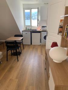 圣丹尼斯Appartement T2 lumineux au cœur du centre-ville的一间带桌子的小厨房和一间餐厅