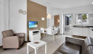 a living room with a couch and a dining room at Apartamentos LIVVO Mar Azul - Adults Only in Corralejo
