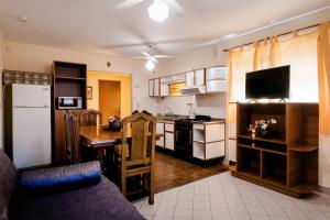 een woonkamer met een keuken met een tafel en een koelkast bij Carlos Paz Departamentos in Villa Carlos Paz