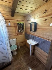 a wooden bathroom with a toilet and a sink at Cabaña Fran in Punta Del Diablo