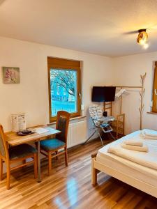 a bedroom with a desk and a bed and a table at Pension Mimosa in Rust